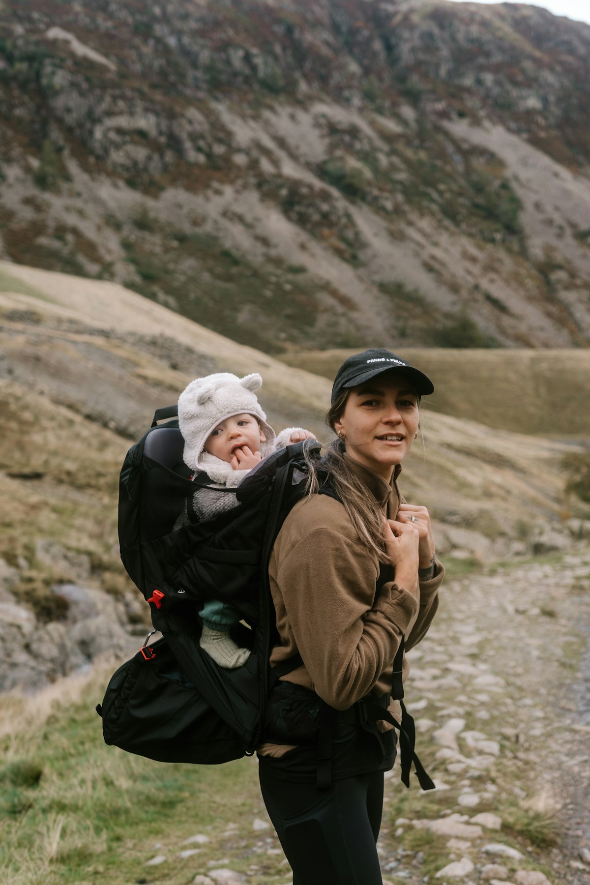 Parent carrying a toddler in a soft carrier
