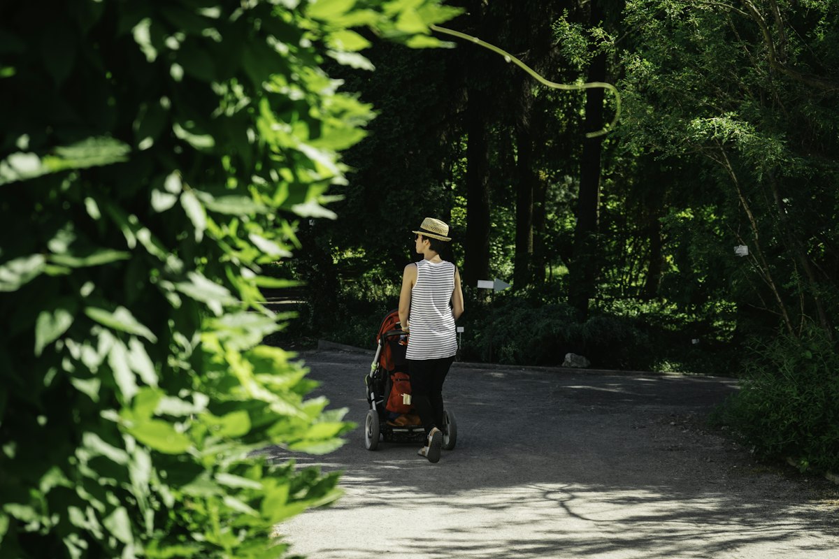 Parent pushing a stroller on a smooth greenway